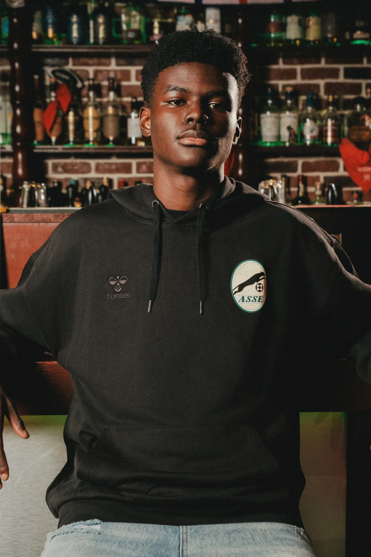 Un modèle porte un sweat de la collection Black Panther d’ASSE et hummel