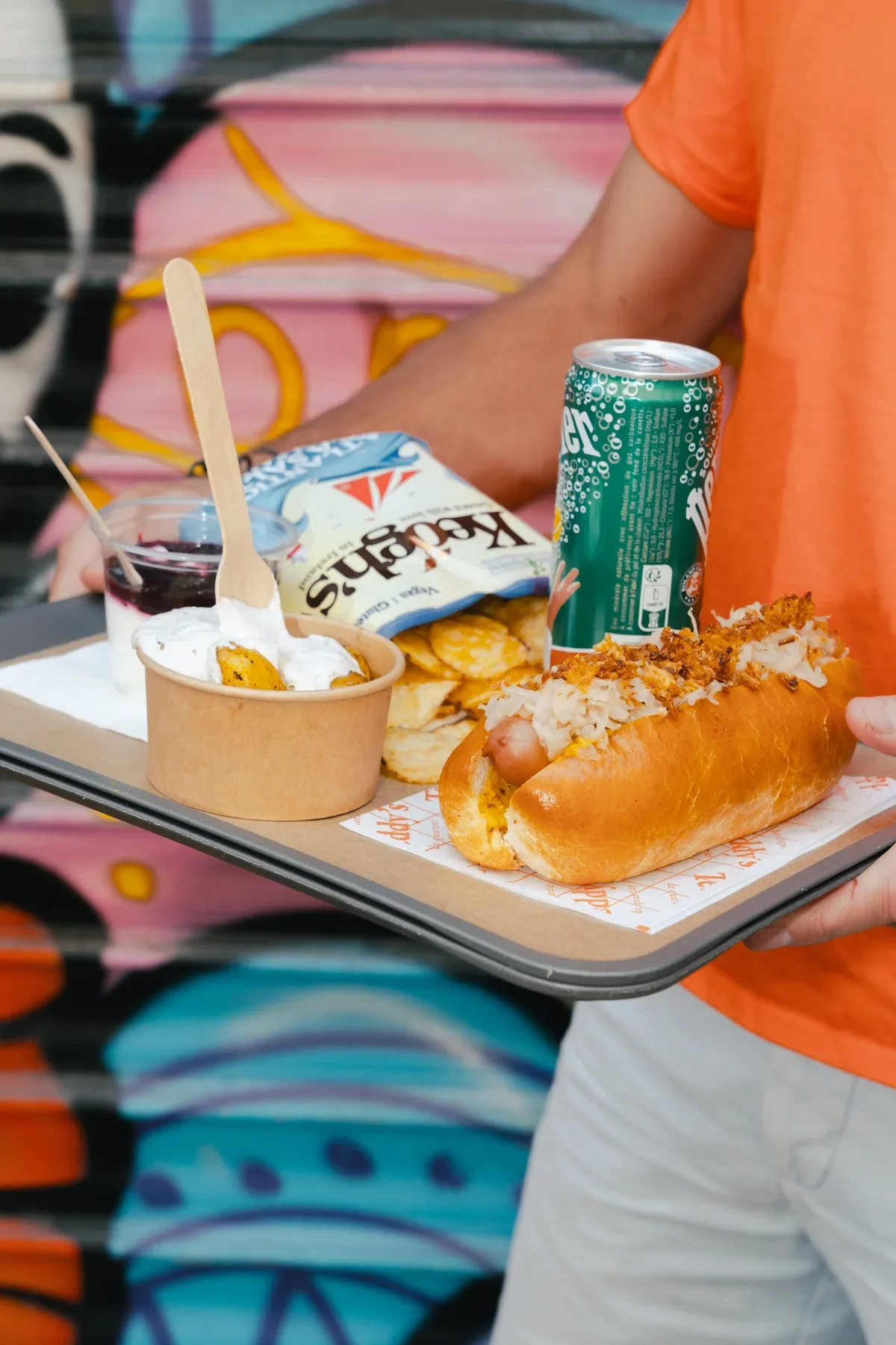 Street food servie sur un plateau devant un décor urbain peint