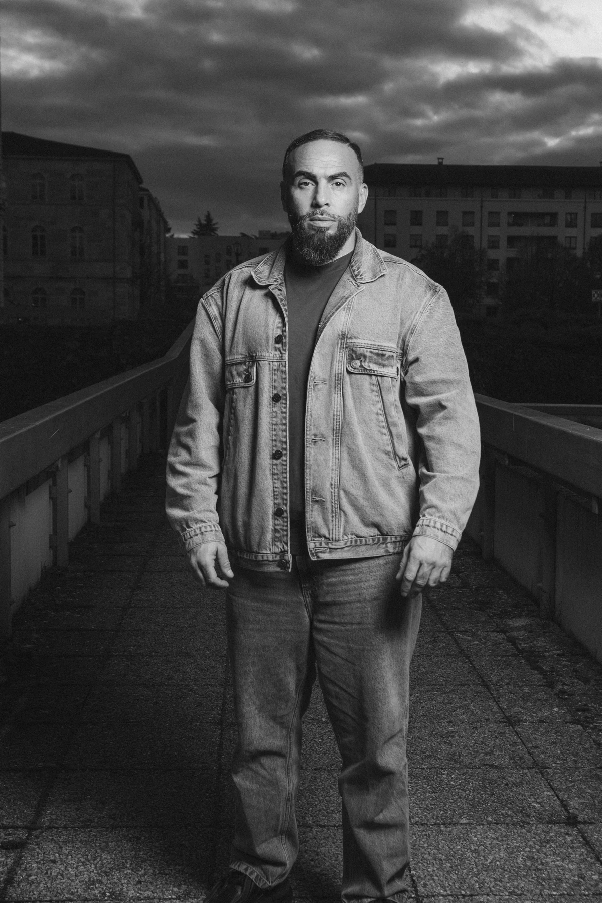 Portrait noir et blanc du rappeur Médine sur une terrasse urbaine